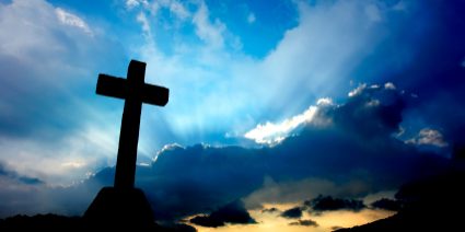 cross detail in silhouette and the clouds in the sky